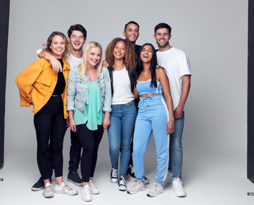 Group Studio Photo Shoot Of Young Multi-Cultural Friends Smiling And Laughing At Camera